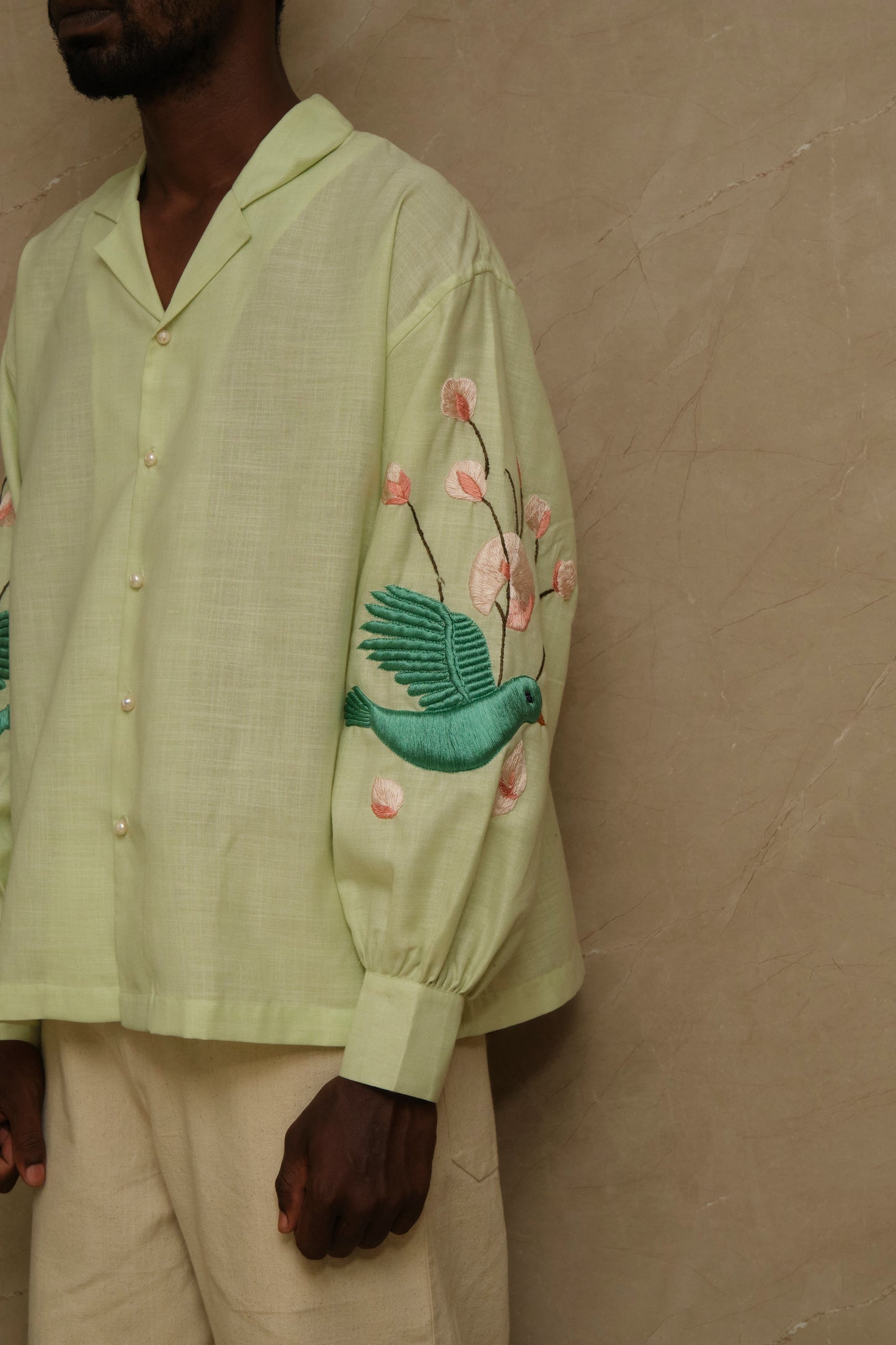 Hiral Parind one of one hand embroidered silk shirt featuring birds in flight, layered satin stitch embroidery, pearl buttons, and slow crafted collector focused wearable artwork
