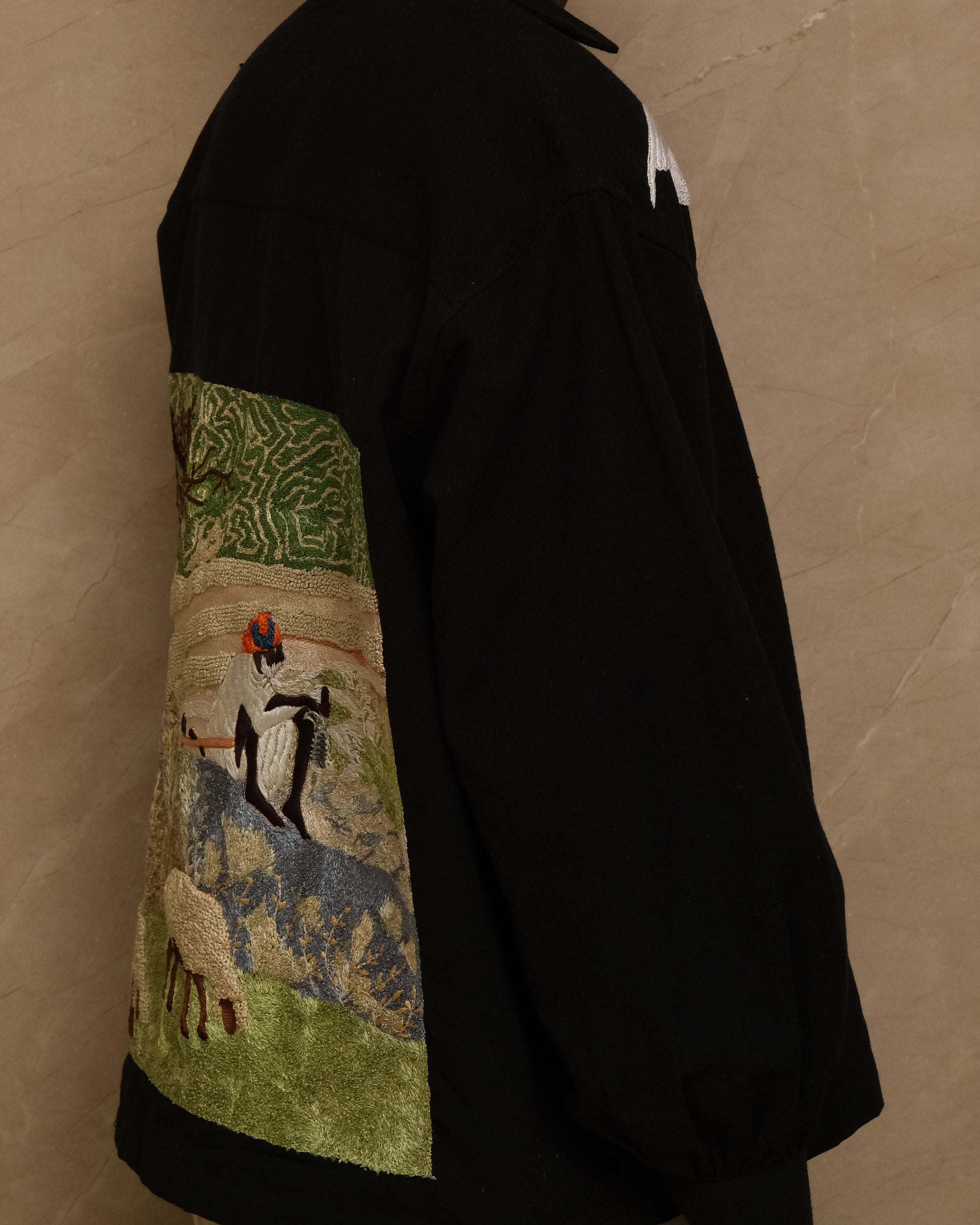 Sambhar 1.0 hand embroidered art shirt exploring pastoral landscapes through threadwork, shepherd imagery, grazing sheep motifs, and slow crafted textile storytelling shaped into a one of one wearable artwork