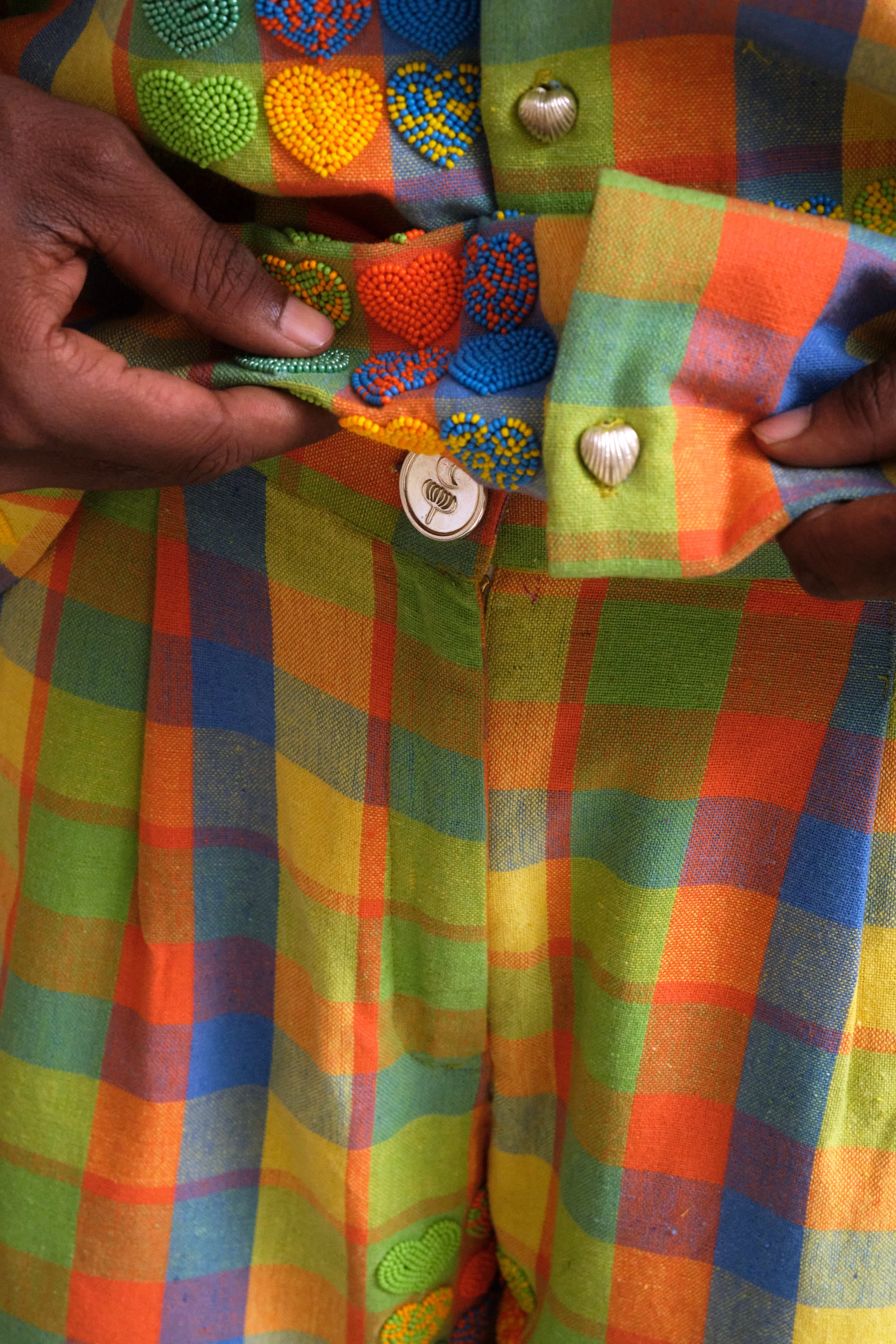 Mirage Shorts one of one handcrafted artwear piece featuring checkered textile construction, heart shaped bead embroidery, and slow crafted collector focused detailing. button close up made in pure silver