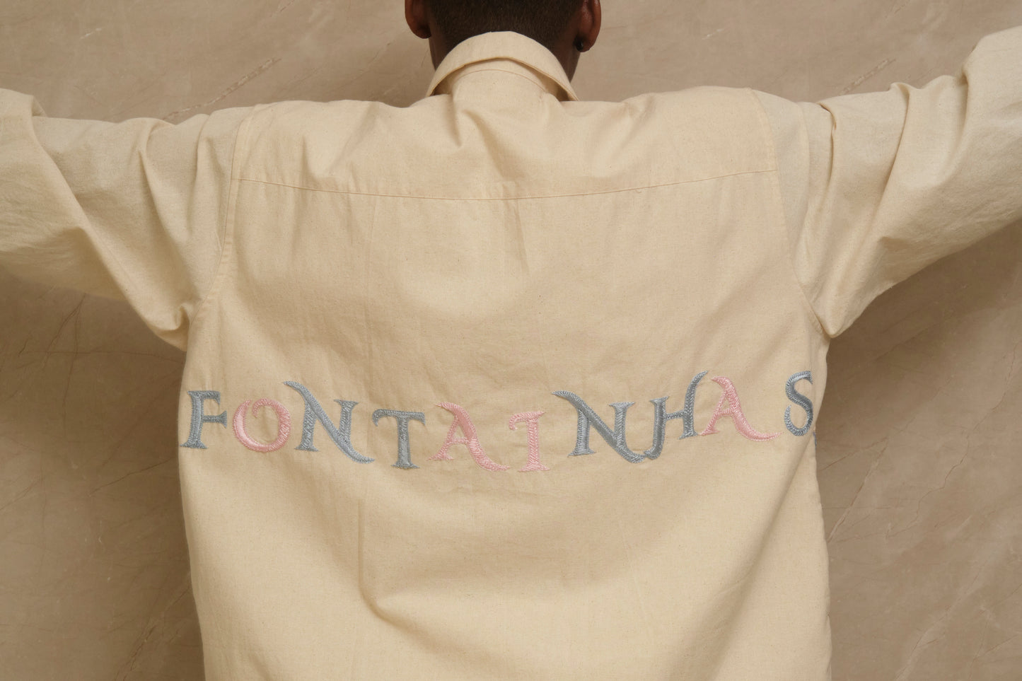 Close study of the Fontainhas embroidered shirt showing layered threadwork, hand finished details, pearl buttons, silver elements, and textured cotton surface crafted slowly by hand