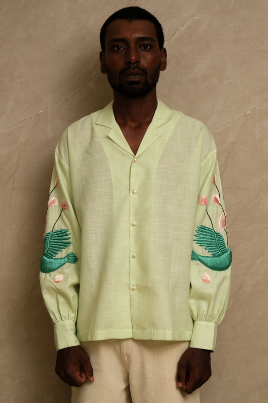 Hand embroidered Hiral Parind collector shirt showcasing detailed bird motifs, sage green silk fabric, handcrafted stitching, and heritage inspired wearable textile craftsmanship