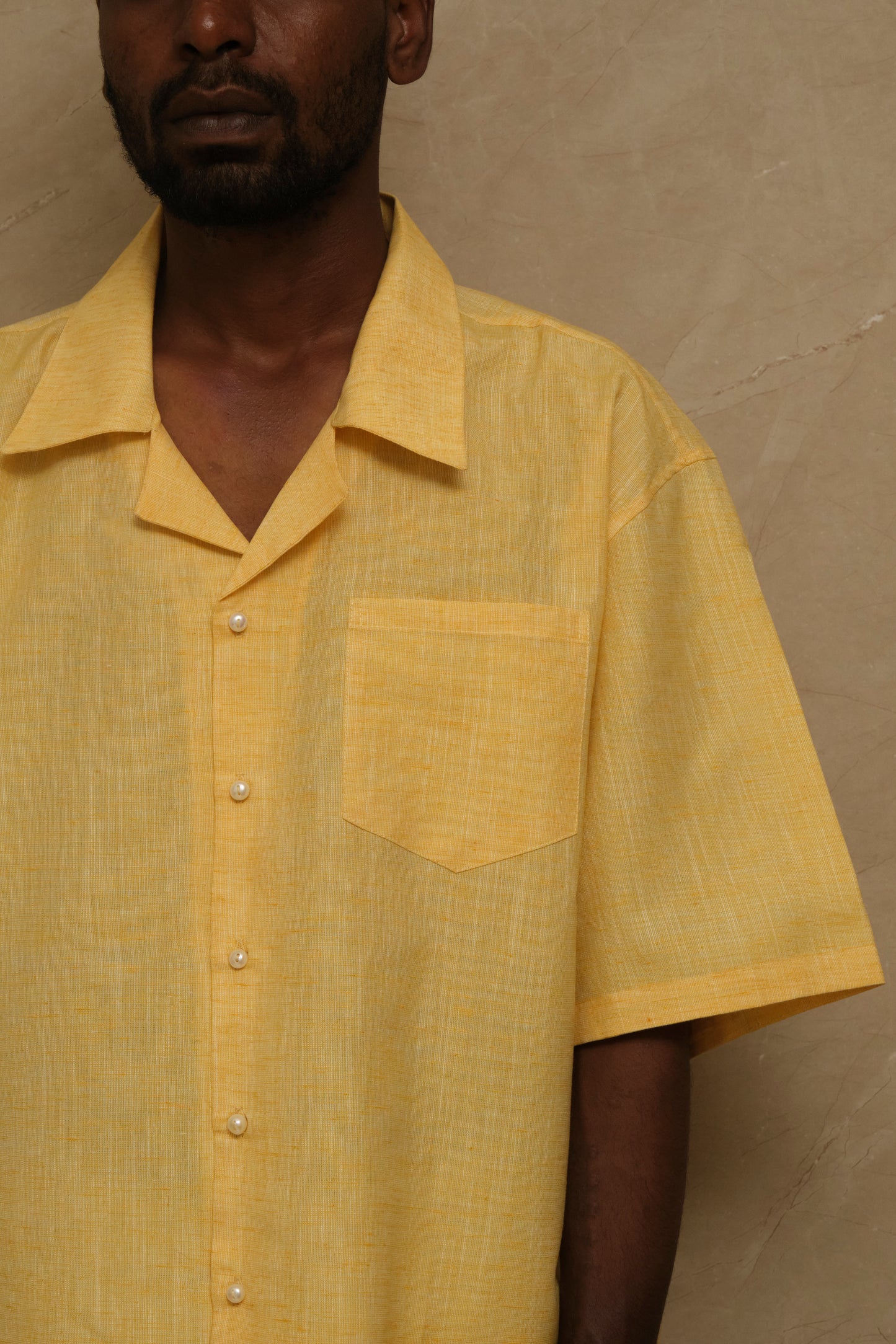 Handcrafted Mango collector shirt showcasing textured linen fabric, pearl ornamentation, and minimal wearable textile craftsmanship photographed in an editorial setting