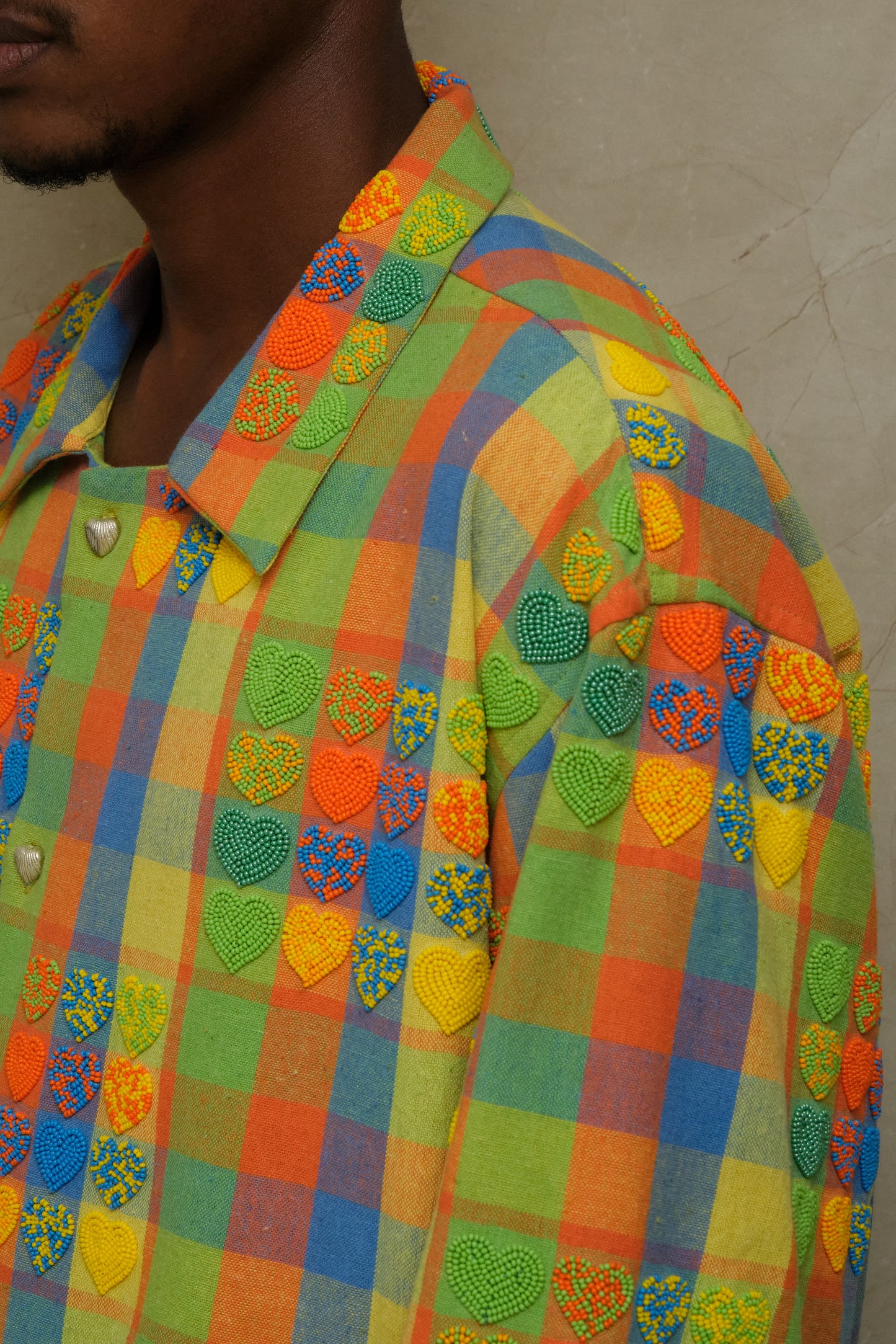 Handcrafted Mirage wearable artwork showcasing intricate bead embroidery, textured checkered fabric, artisanal ornamentation, and vintage inspired textile craftsmanship photographed editorially