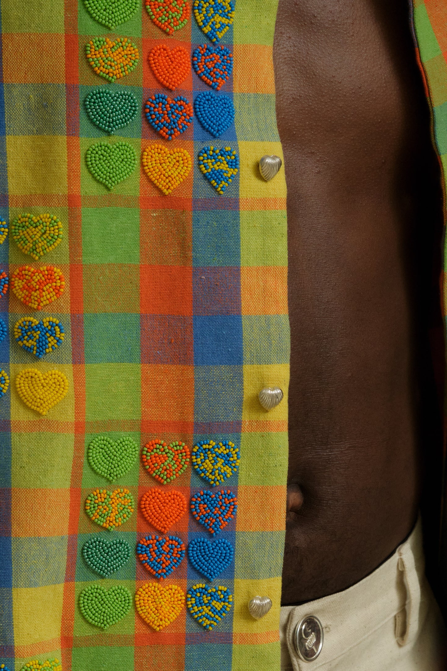 Close study of the Mirage embroidered shirt showing heart bead detailing, layered textile textures, handcrafted stitching, and one of one collector level artwear construction