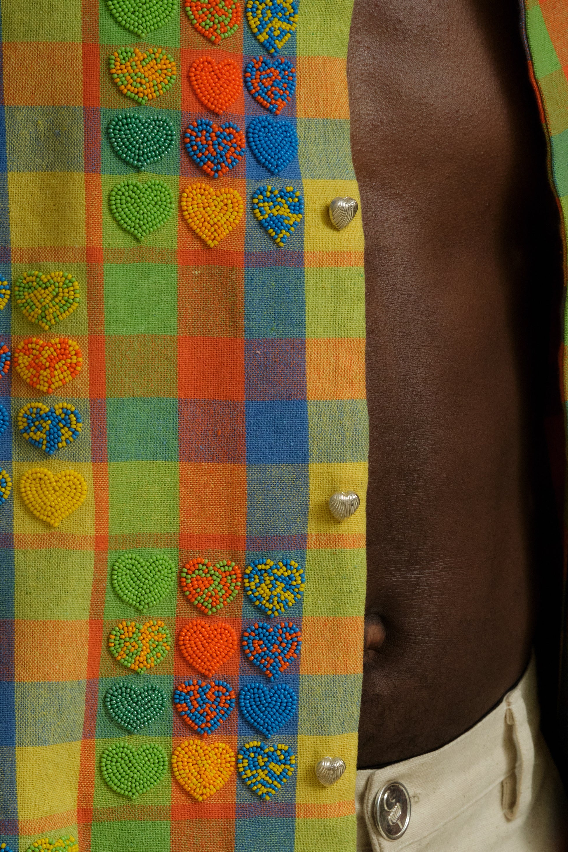 Close study of the Mirage embroidered shirt showing heart bead detailing, layered textile textures, handcrafted stitching, and one of one collector level artwear construction