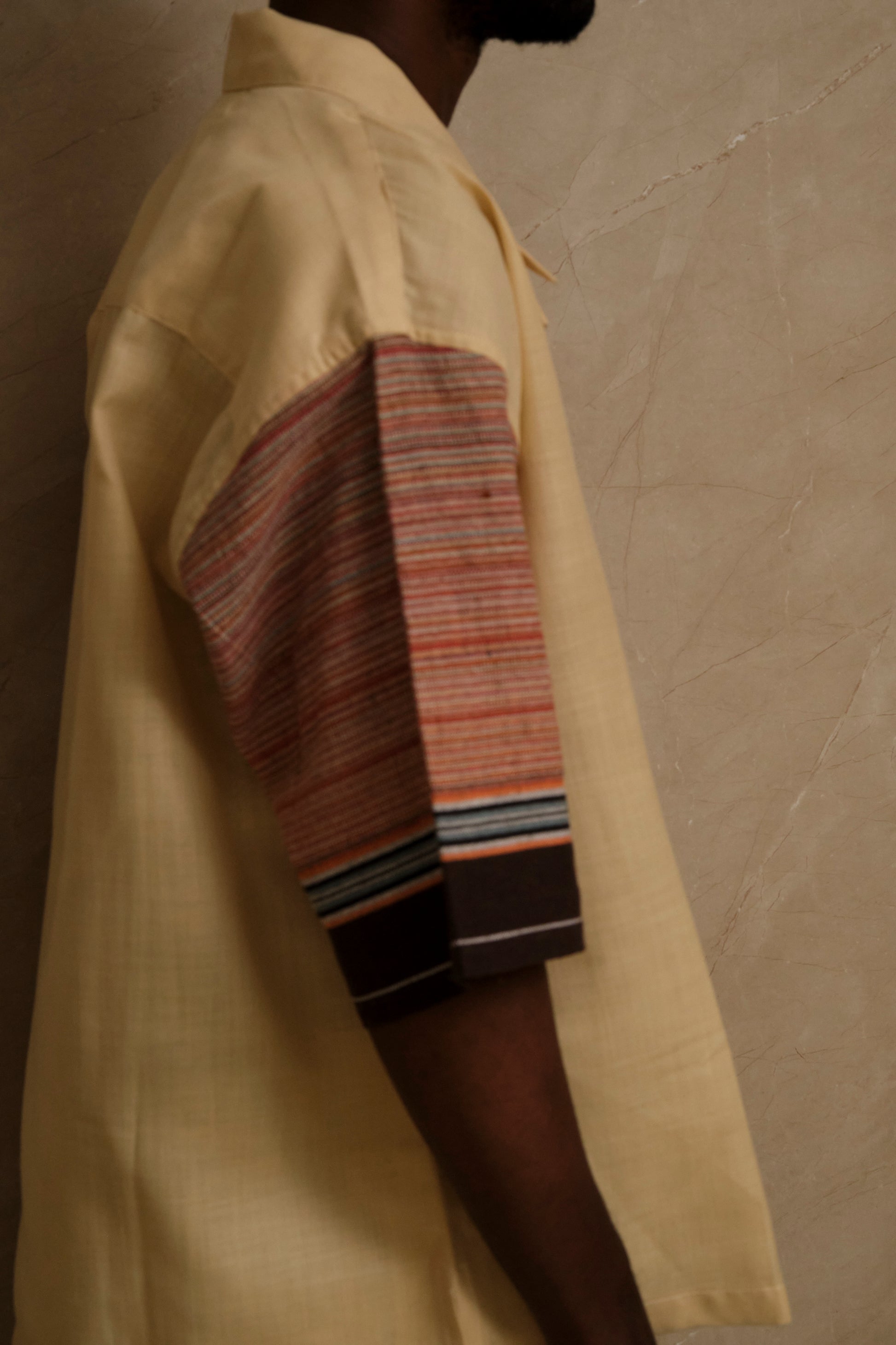 Detailed close up of Rock 1.0 showing textured canvas fabric, handcrafted stitching, heritage textile references, and artisanal wearable textile detailing