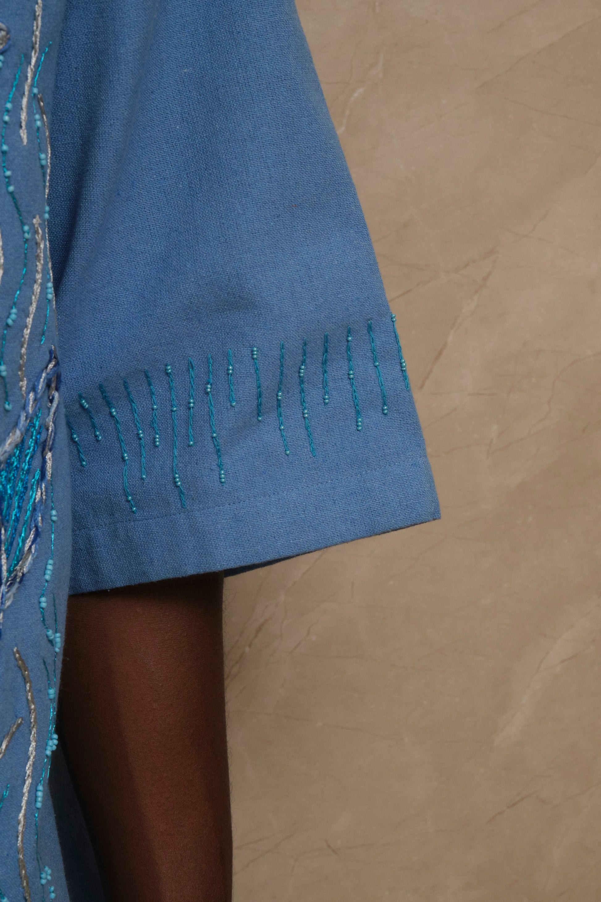 The Ocean embroidered textile artwork photographed in soft natural light highlighting handcrafted stitching, wave inspired surface detailing, and slow constructed artisanal craftsmanship