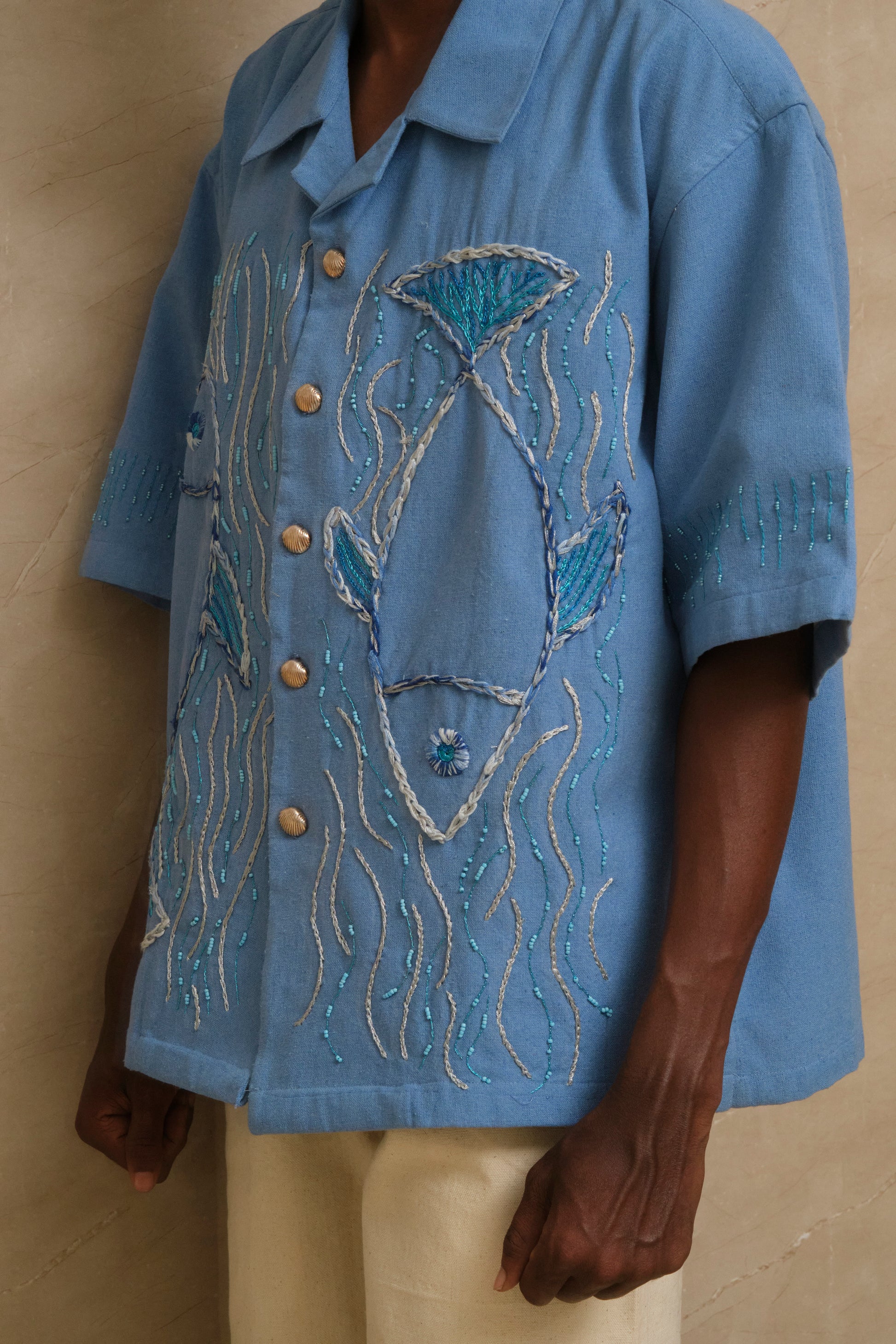 The Ocean one of one hand embroidered collector shirt featuring fish and wave inspired textile artwork, bead detailing, silver ornamentation, and slow crafted wearable art construction